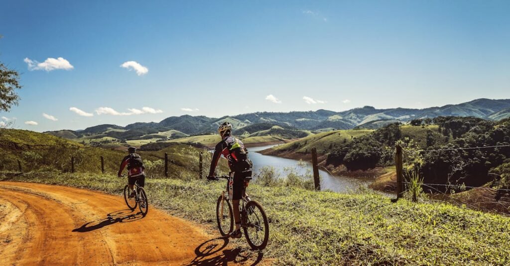 cyclists-trail-bike-clouds-163407-163407 Two cyclists riding on a dirt trail with stunning mountain views and clear skies.
